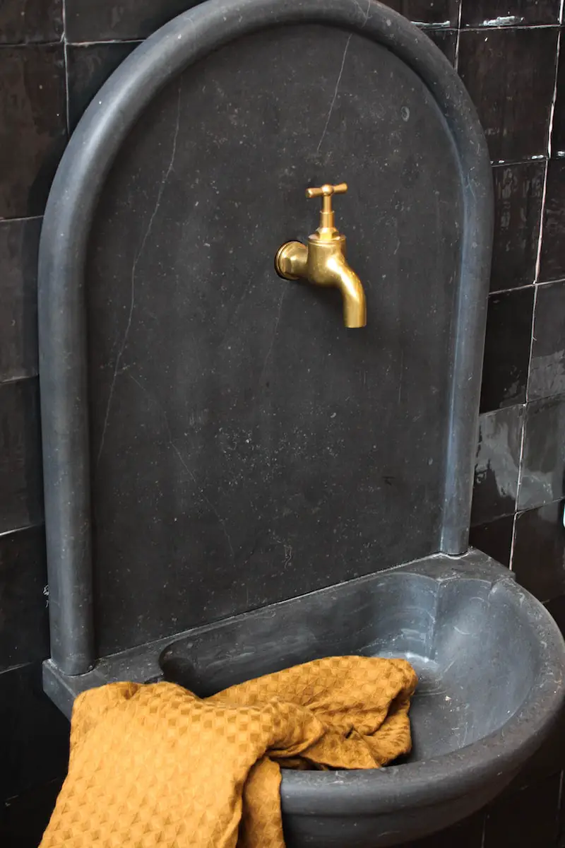yellow and brown faucet on black ceramic sink